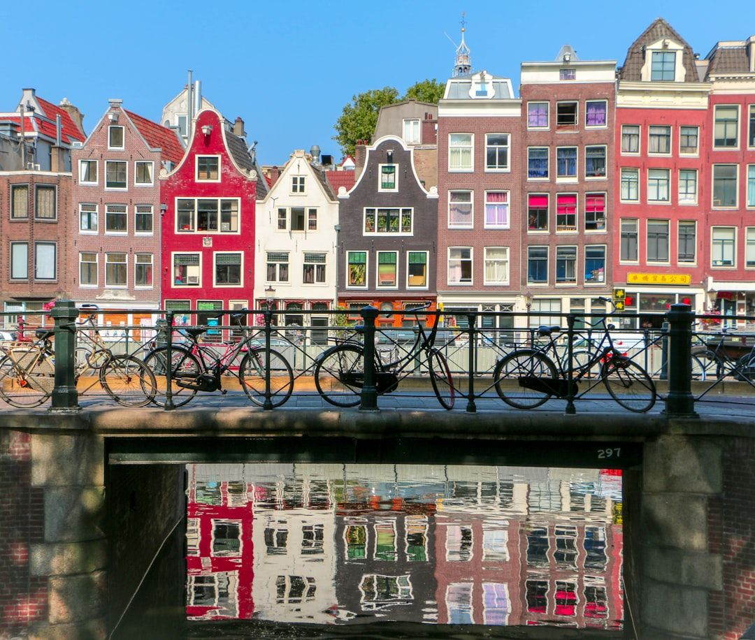 Narrow gabled canal houses reflected in an Amsterdam canal at dusk