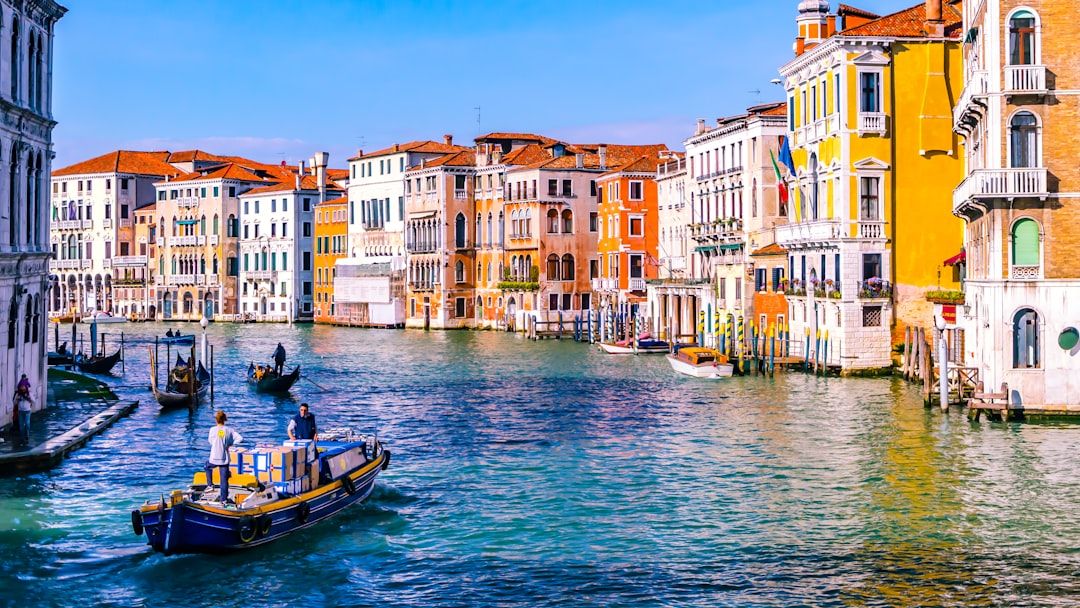 Quiet side canal in Cannaregio Venice with moored boats and pastel buildings