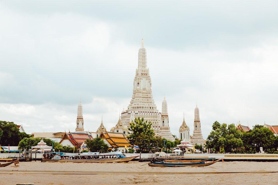 Wat Arun temple spire on the Chao Phraya river bank in Bangkok at sunset